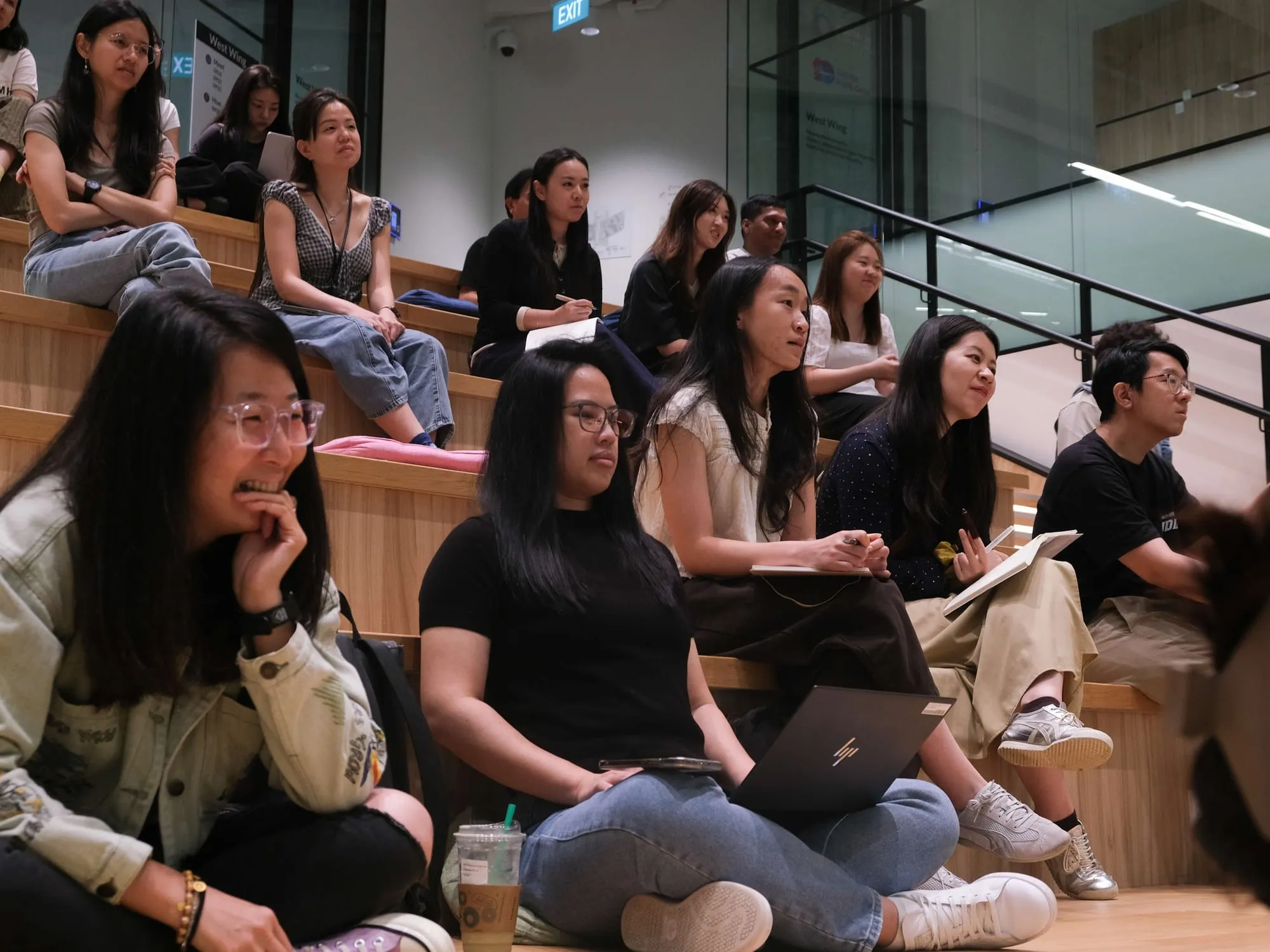 Attendees smiling and listening on the tiered seating.