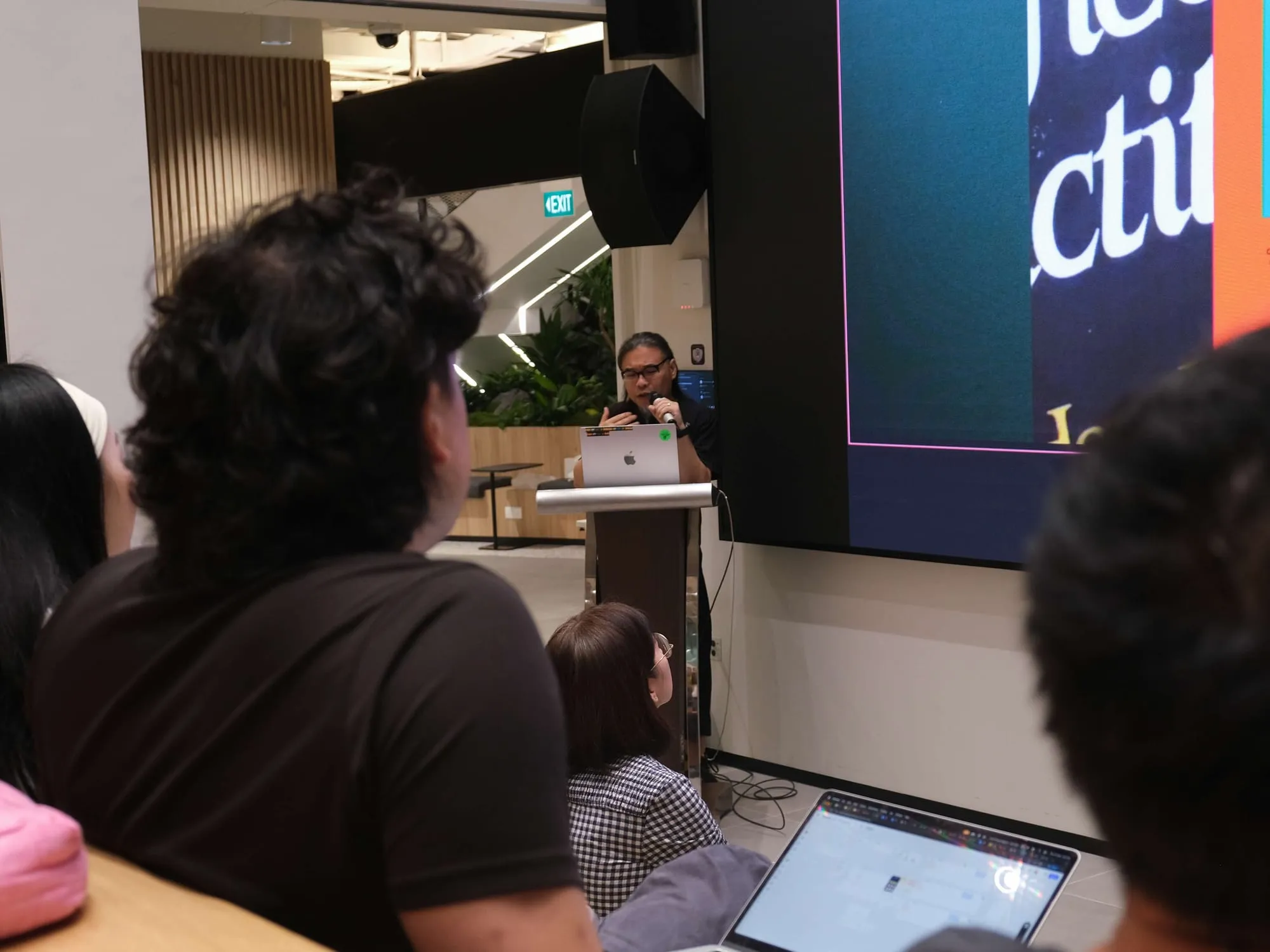 An attendee watches Pann present from the back of the room.