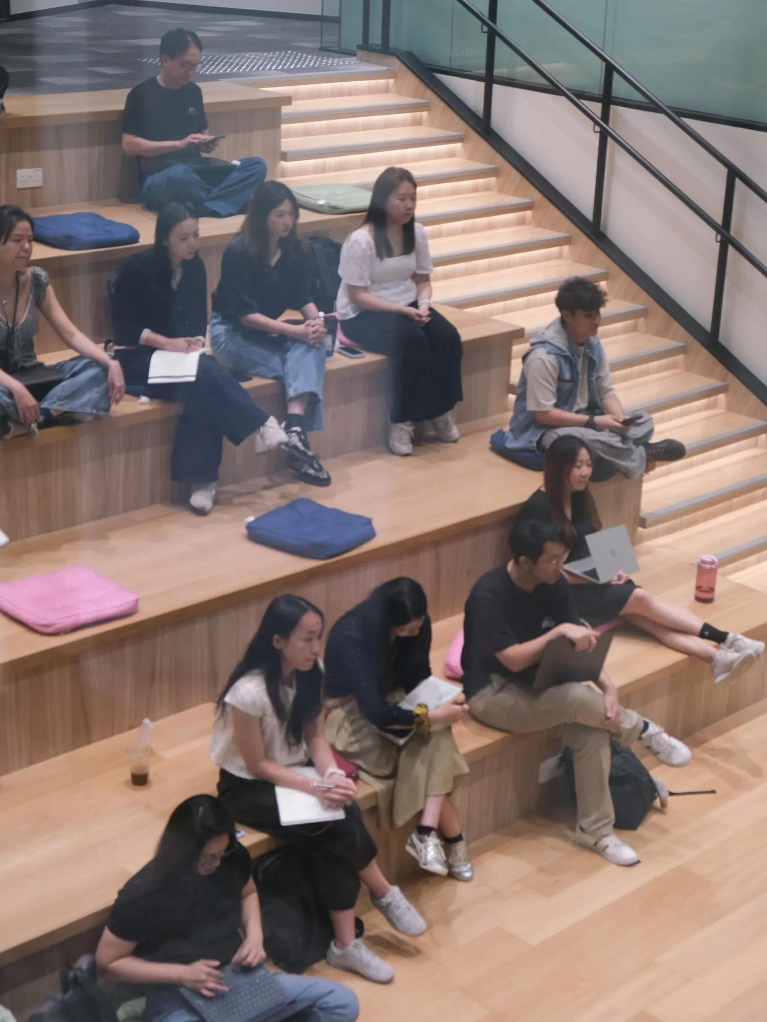 Attendees seated on the steps, listening.