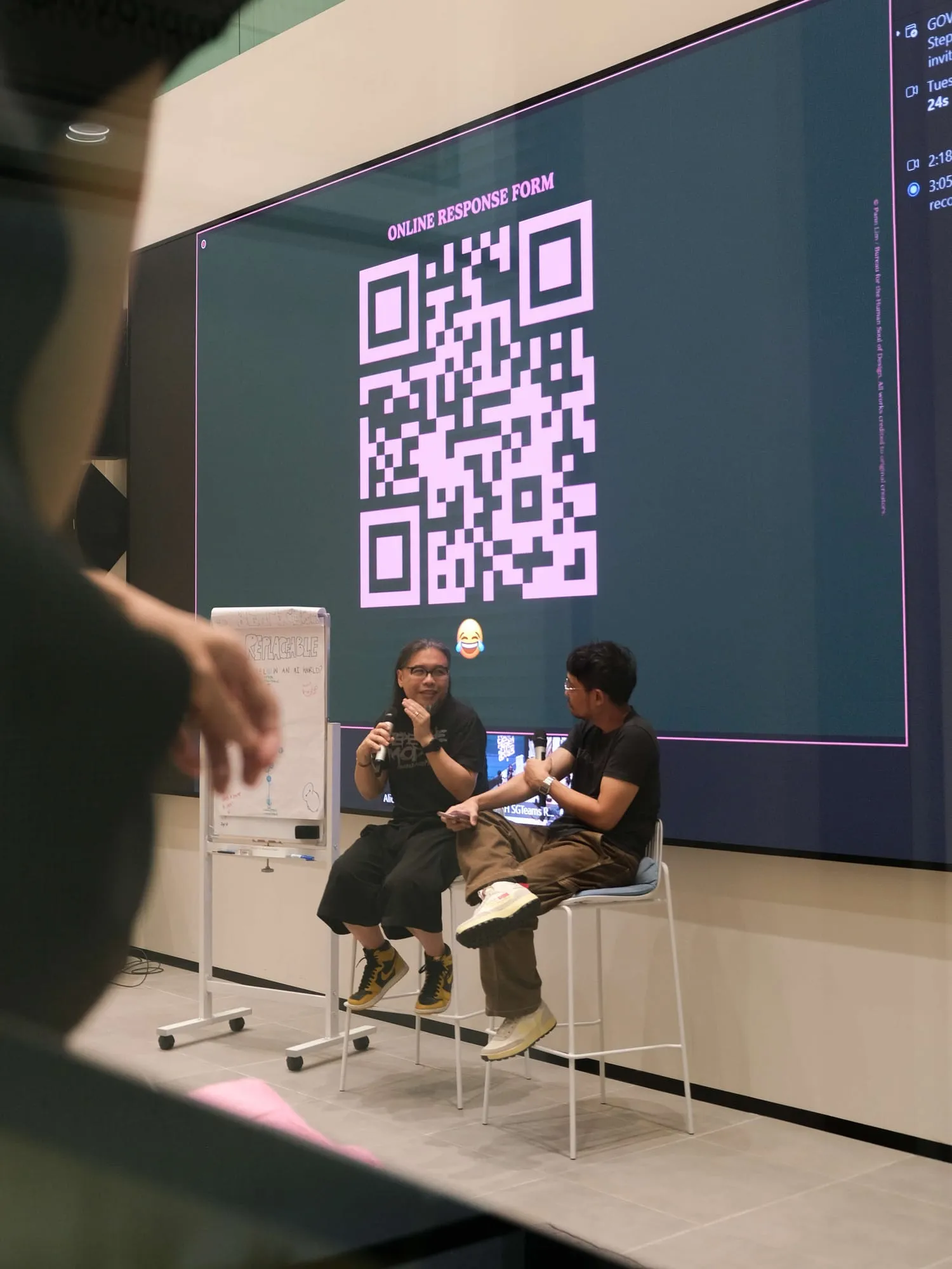 Pann and the moderator on stools for the Q&A, in front of a screen with a QR code.
