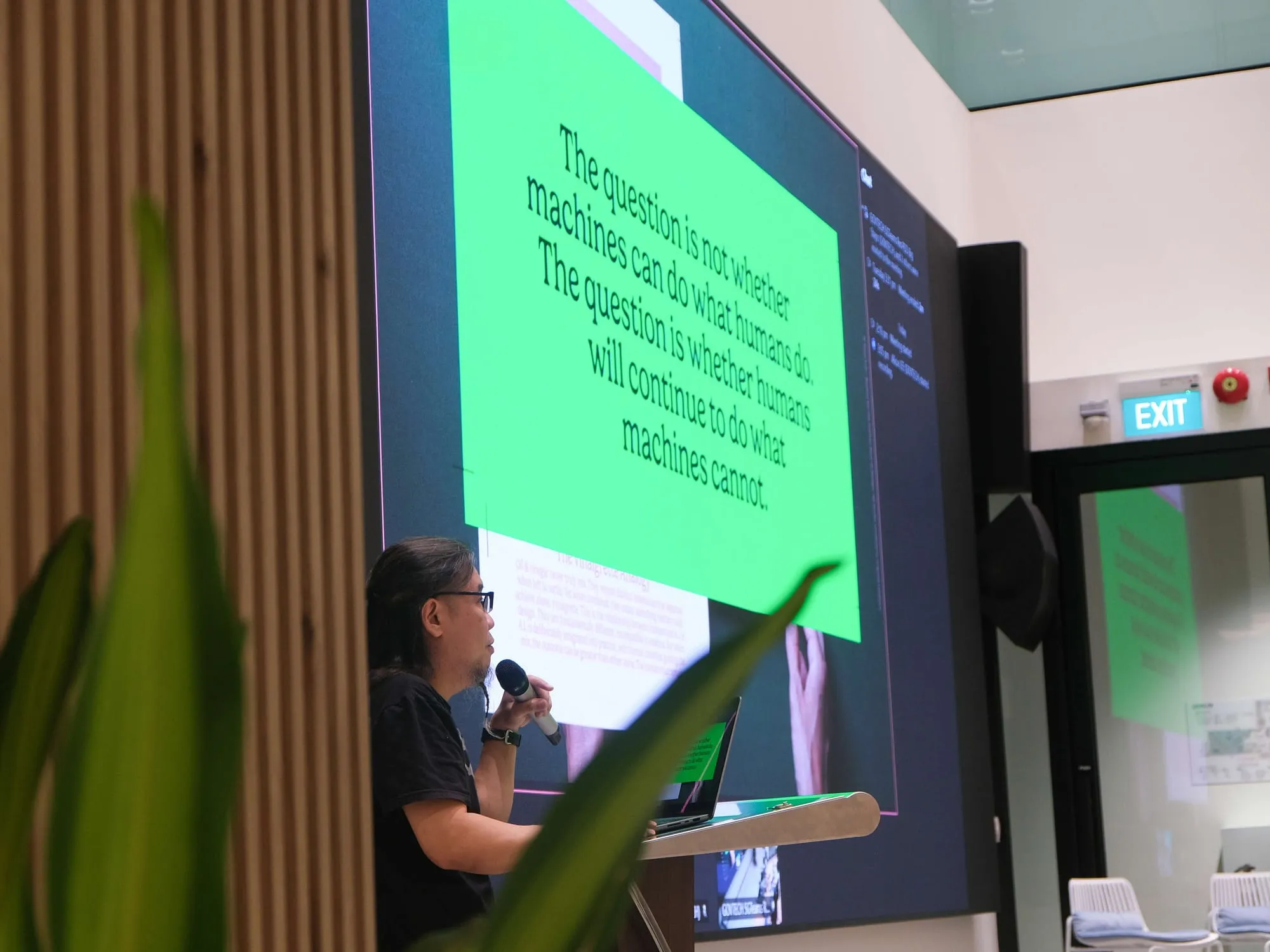 Pann at the lectern beside a slide of the quote below.